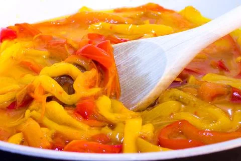 Yellow and red peppers while cooking Stock Photos