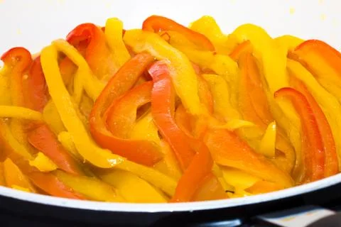 Yellow and red peppers while cooking Stock Photos