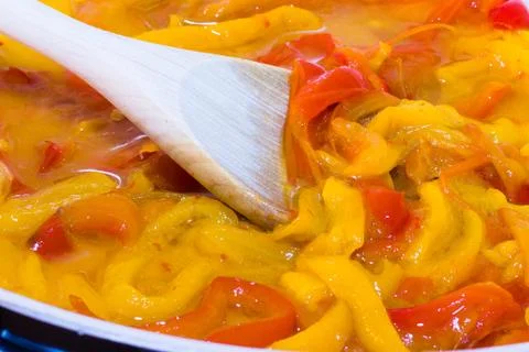 Yellow and red peppers while cooking Foto stock