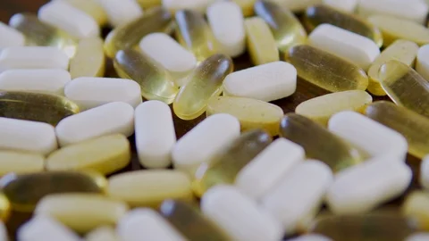 Yellow and white pills on the table, slowly approaching focus on macro close up Stock Footage 125636997