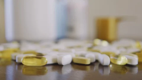 Yellow and white pills on the table, slowly approaching focus on macro close up Stock Footage 126271804