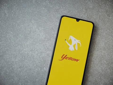 Yellow app launch screen with logo on the display of a black mobile smartphon Stock Photos