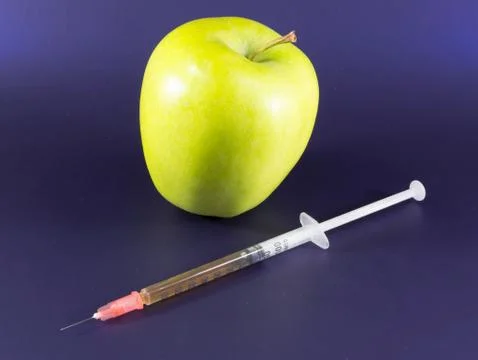 Yellow Apple and Hypodermic Syringe. Stock Photos