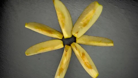 Yellow apple, cut into slices, on a black background. Stock Footage 148426546