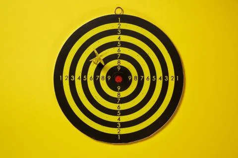 Yellow arrow dart hitting the target dartboard Stock Photos