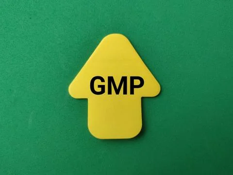 A yellow arrow-shaped note with the bold black text GMP points upward on a .. Stock Photos