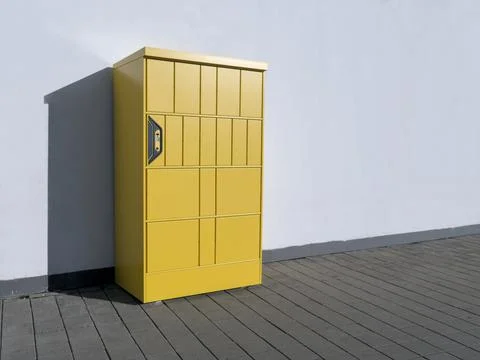 Yellow automatic parcel locker machine standing on the street Stock Photos