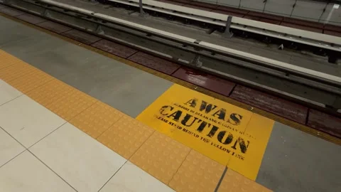Yellow “AWAS CAUTION” safety warning marking beside the railway track Stock Footage 342368929