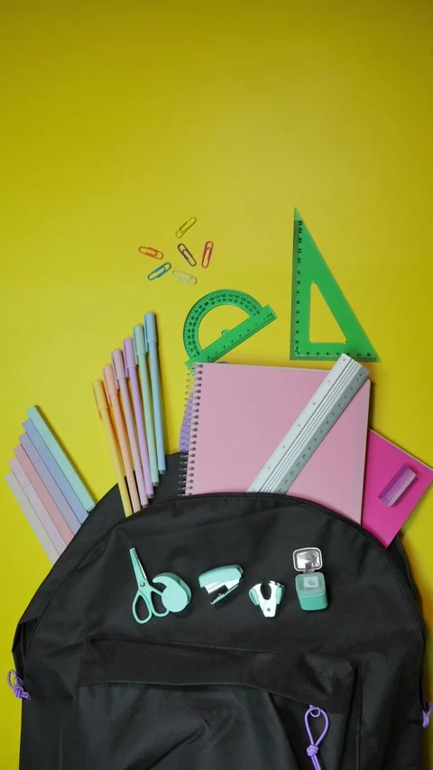 Yellow background with black school bag and school supplies moving out of it Stock Footage 283670025