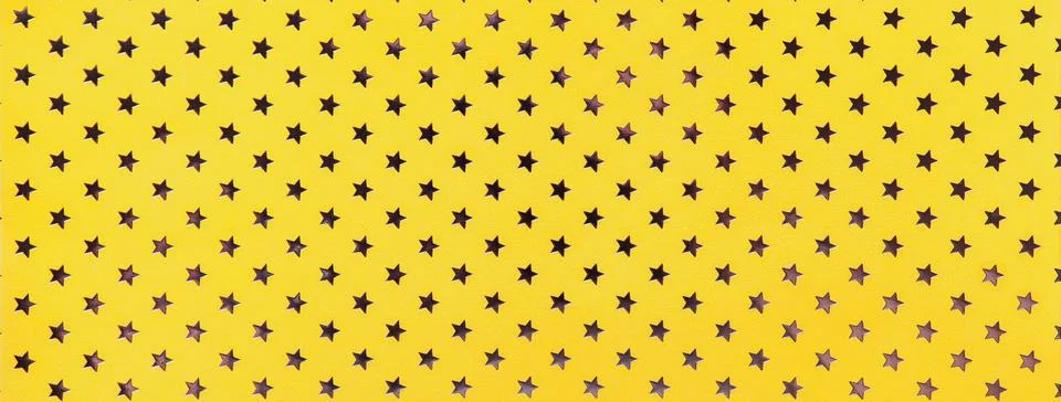 Yellow background from foil paper with pattern silver stars, closeup. Stock Photos