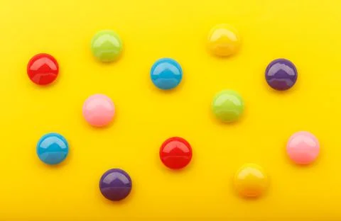 Yellow background with multicolored round buttons Stock Photos