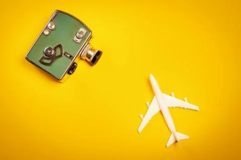 Yellow background with an old camera and a toy airplane Foto stock