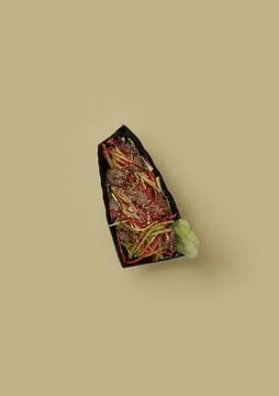 On yellow background in a rectangular black plate, fried veal with striped Foto stock