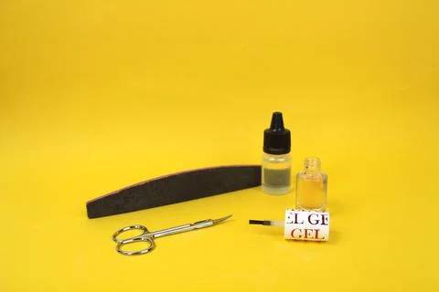 On a yellow background there are items for manicure, open nail polish Stock Photos