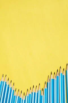 Yellow background with vertical space for text and pencils. Back to school flat Stock Photos