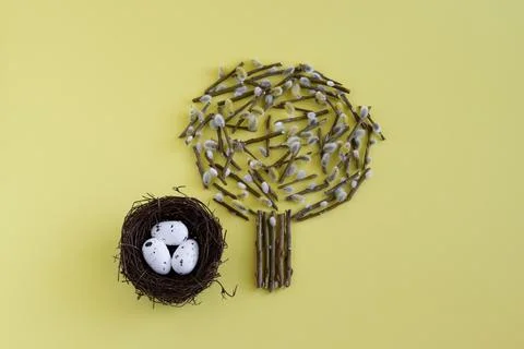 On a yellow background willow tree, lined with branches and a nest with Easte Stock Photos