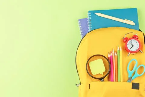 Yellow backpack with notebooks and study supplies. Foto stock