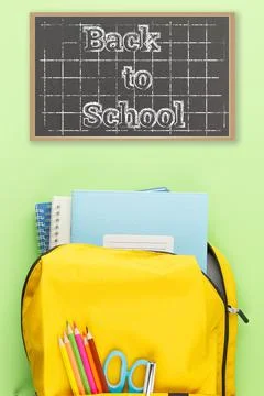 Yellow backpack with notebooks and study supplies. Stock Photos