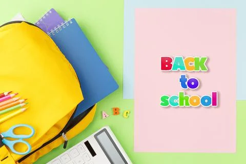 Yellow backpack with notebooks and study supplies. Stock Photos