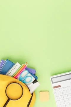 Yellow backpack with notebooks and study supplies. Stock Photos