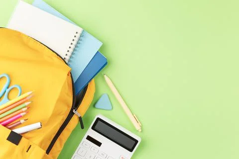 Yellow backpack with notebooks and study supplies. Foto stock