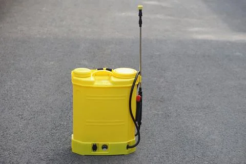 Yellow backpack sprayer placed on asphalt road, used for agriculture, pest contr Stock Photos