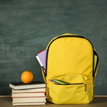Yellow backpack stack books orange Stock Photos
