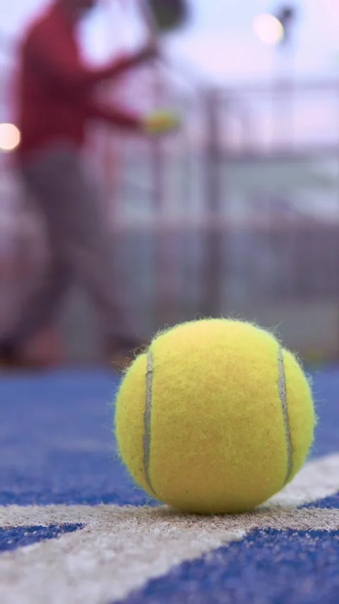 Yellow ball on floor behind padel net in court outdoors. Man playing paddle. Stock Footage 312951647