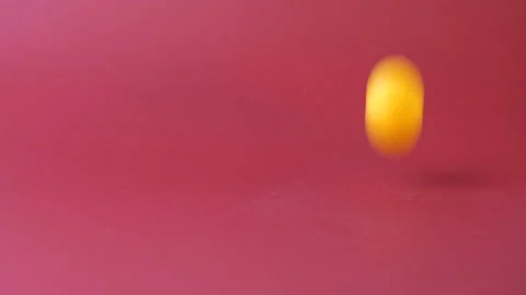 Yellow ball jumps on a red background 4K Stock Footage 126805360