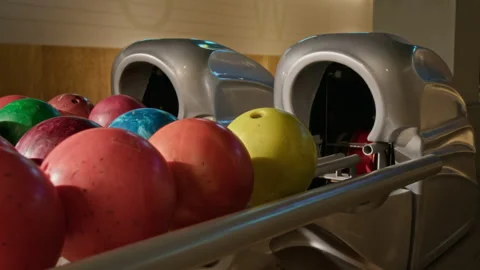 Yellow Ball Rolling out of Return Machine in Bowling Alley Stock Footage 337094132