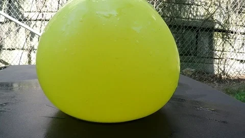 Yellow balloon cutting with a sharp knife in slow motion Stock Footage 94734517