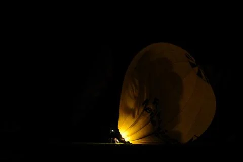 Yellow balloon is illuminated at night on a meadow Stock Photos