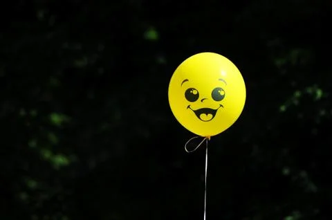 Yellow balloon on a string with a painted face Stock Photos