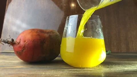 Yellow beet juice in glass on  table Stock Footage 100256773