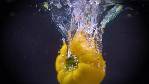 Yellow bell pepper fall into water Stock Footage 122979740