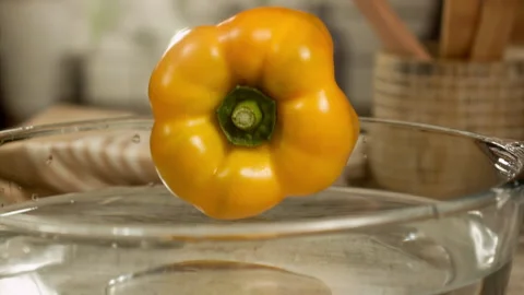 Yellow bell pepper falling into water in slow motion Stock Footage 152904826