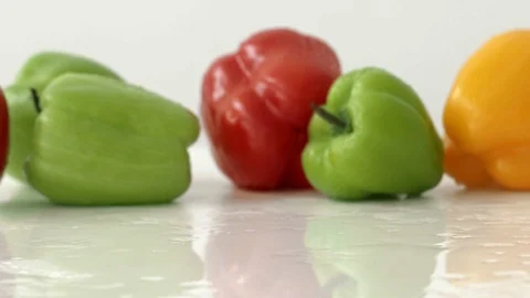 Yellow bell pepper rolls on the table on the background of fresh bell peppers in Stock Footage 94122379