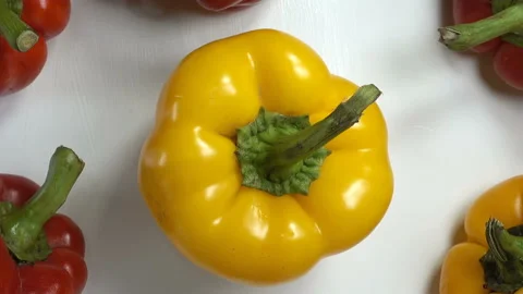 Yellow bell pepper surrounded by red peppers Video stock 142149814