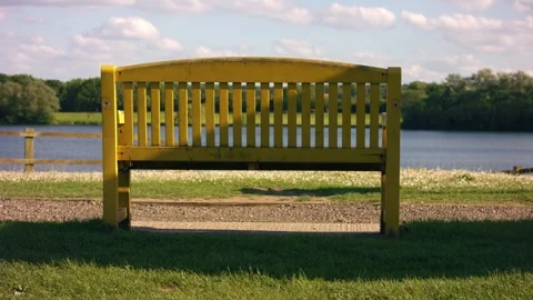 Yellow bench looking out onto lake Vídeo Stock 336957139