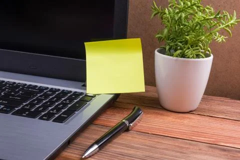 Yellow blank note for ad on computer pc screen, office desk table with suplies Stock Photos