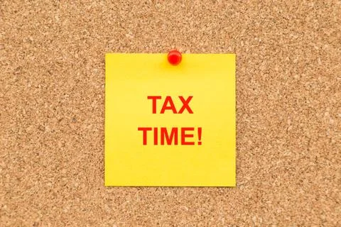 Yellow blank note and written TAX TIME for reminder. Stock Photos