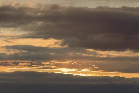 A yellow, blue sunset with thick clouds in the sky before a storm with a dark Stock Photos