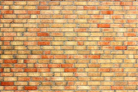 Yellow brick wall with red bricks Stock Photos