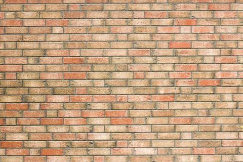 Yellow brick wall with red bricks Stock Photos
