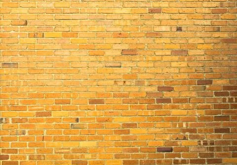 Yellow brick wall seamless background Stock Photos