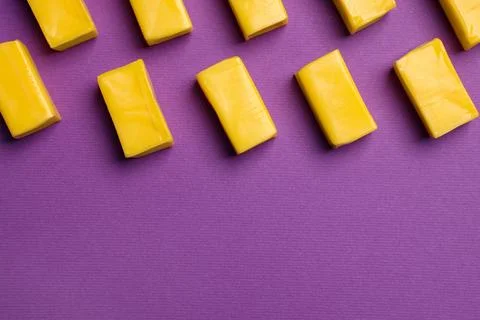 Yellow bubble gums on purple background, flat lay. Space for text Stock Photos