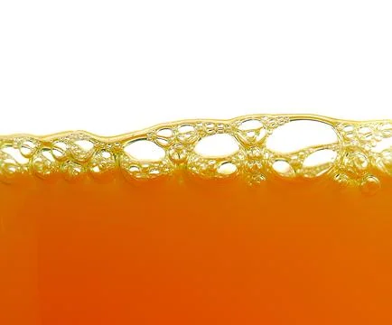 Yellow bubbles in the orange juice Stock Photos