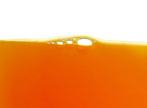 Yellow bubbles in the orange juice Stock Photos