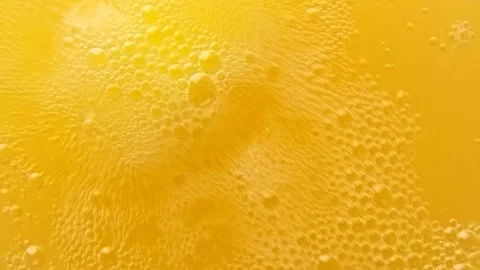 Yellow bubbling liquid boiling texture. Carbonated drink background. Stock Footage 147385886