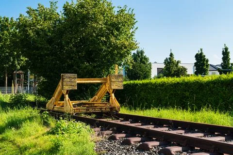 A yellow buffer stop at the end of a railway track. Stock Photos
